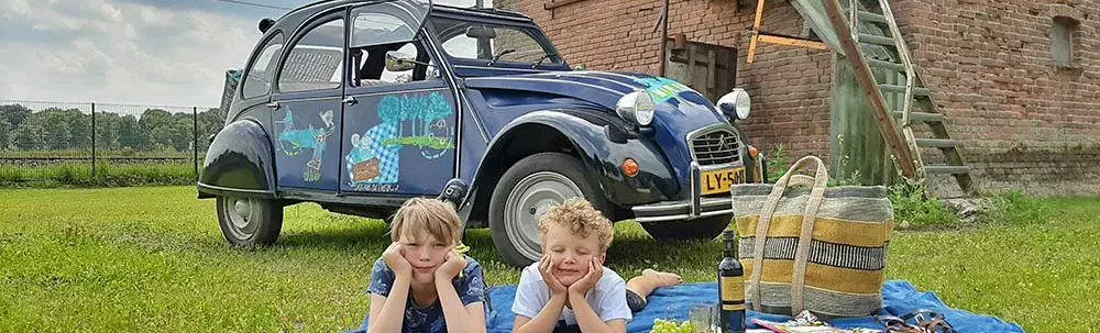 2CV eend met twee kinderen op picknickkleed